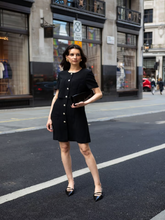 A lady wears a double-layer black dress